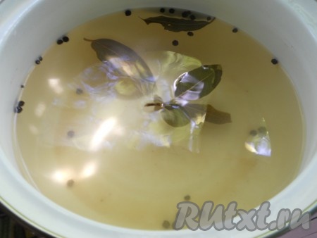 Снова влить в банку с помидорами чистую кипящую воду. Прикрыть банку крышкой и оставить минут на 5, после этого снова вылить воду в раковину. Пока помидоры в банке второй раз залиты кипятком, нужно сварить маринад. Для этого в кастрюлю нужно влить 500 миллилитров воды, добавить соль, сахар, лавровые листья и горошины чёрного перца, перемешать, дать закипеть, проварить 2-3 минуты, чтобы сахар и соль полностью растворились, затем влить в кастрюлю уксус, дать закипеть и сразу убрать маринад с огня.