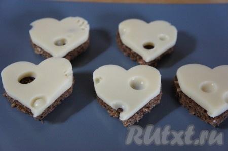 Начинаем собирать канапе. На плоскую тарелку кладём хлеб, сверху - сыр.