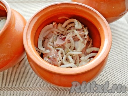 Глиняные горшочки смазать внутри растительным маслом. Мясо разложить по горшочкам.