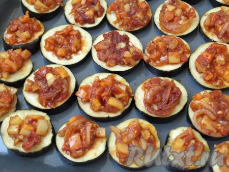 Баклажаны промокнуть салфеткой, выложить на противень (если противень антипригарный, его можно не смазывать растительным маслом). На каждый кружок выложить по 1 столовой ложке овощной смеси.