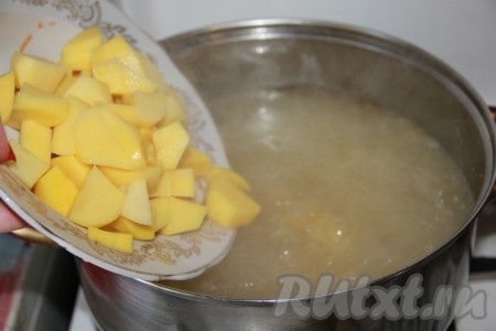 После того как горох станет мягким, снять кастрюлю с огня. Достать рёбрышки из кастрюли, дать им немного остыть. В кастрюлю с бульоном и горохом добавить очищенный и нарезанный на кусочки картофель, дать закипеть и варить на небольшом огне минут 15 (до мягкости картошки).