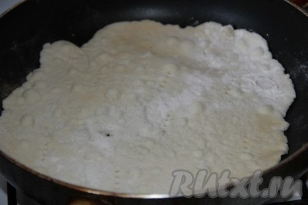 Раскатываем на присыпанном мукой столе 1 кусочек теста в пласт диаметром чуть больше сковороды и выкладываем на разогретую сухую сковородку.