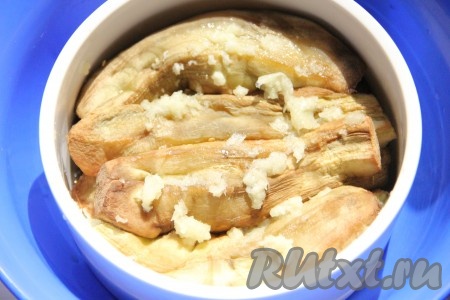 Готовые баклажаны выкладывать слоями, каждый слой баклажанов перемазывать выдавленным через пресс чесноком. Таким образом выложить все баклажаны.
