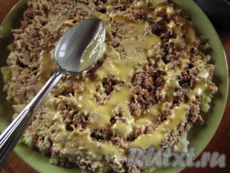 Выложить лосось поверх картошки. Смазать сверху парой ложек майонеза.