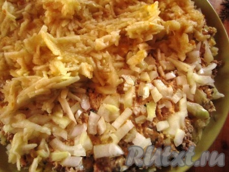 Следующим слоем выложить лук. Яблоки очистить от шкурки и удалить середину. Натереть яблоки на крупной тёрке и выложить поверх лука.