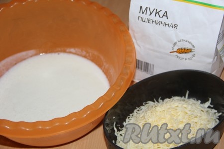 В глубокую миску добавить кефир, соду, сахар и соль. Всё хорошо перемешать. Затем добавить сыр и просеянную муку.
