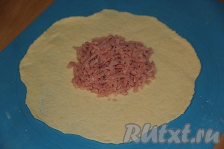 Каждую часть теста раскатать в лепёшку, на середину выложить примерно 1,5 столовые ложки ветчины.
