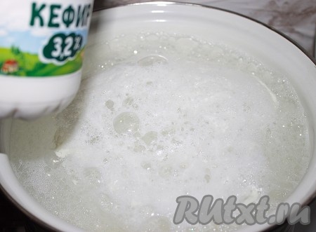 Молоко вылить в кастрюлю, поставить на огонь и довести до кипения. В кипящее молоко вылить кефир.
