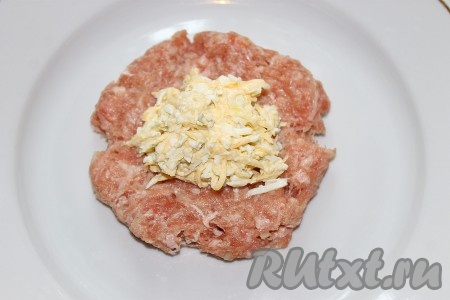 Каждую круглую заготовку фарша размять руками в лепёшку, в серединку положить 1-2 чайных ложки начинки из сыра и яиц. Завернуть начинку внутрь фарша, как пирожок.