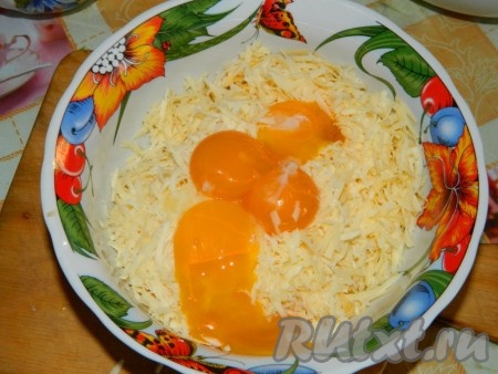 Сыр натереть. Немного отложить для верха, остальной смешать с желтками.