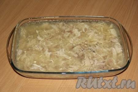  Чеснок почистить и нарезать на лепестки. Разложить мясо по формам, добавить чеснок. Залить мясо бульоном.