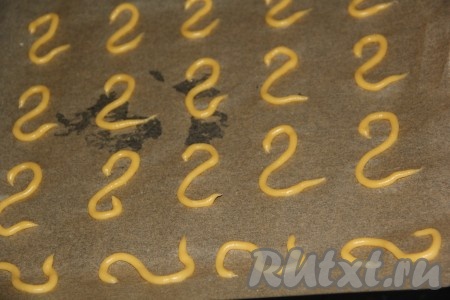 Выложить готовое заварное тесто в кондитерский мешок с тонкой насадкой. Противень для выпекания застелить пергаментом. Выдавить тесто в виде цифры 2 - это будут лебединые головы. Духовку разогреть до 200 градусов. Поставить противень в духовку. Важно знать, что первые 15-20 минут духовку не открывать! Лебединые головы готовятся быстрее, чем лебединые тела, поэтому выпекать их нужно раздельно. У меня на выпечку лебединых голов ушло 15 минут, а на выпечку тел - примерно 25-30 минут. Ориентируйтесь по своей духовке. Готовность частей лебедей определяем по цвету и форме. Они должны иметь красивый золотисто-коричневый цвет.
