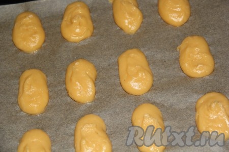 Снять с кондитерского мешка тонкую насадку и выдавить лебединые тела (один конец тела должен быть слегка уже, чем другой). Поставить противень в духовку и выпекать до готовности.