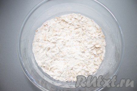 Для верхнего слоя: в миске смешать просеянную муку с разрыхлителем, овсяные хлопья, сахар, ваниль и корицу.
