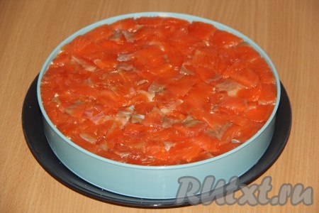 Выложить слой форели. Закрыть слоеный закусочный торт пищевой плёнкой и убрать в холодильник на пару часов.&nbsp;
