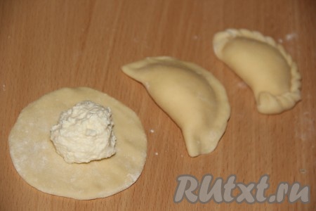 На середину круга выложить начинку, хорошо скрепить края вареников.
