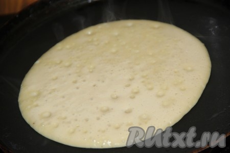 Затем перелить тесто в миску, влить растительное масло и тщательно перемешать. Сковороду хорошо разогреть, смазать слегка растительным маслом перед жаркой первого панкейка, в дальнейшем сковороду смазывать не надо. Вылить небольшой половник теста в центр раскалённой сковороды. Распределять тесто по сковороде не нужно. Жарить панкейк на среднем огне до подрумянивания снизу, перевернуть его.