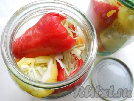 Фаршированный перец уложить плотно в стерилизованные и сухие банки (отверстием с капустой вверх).