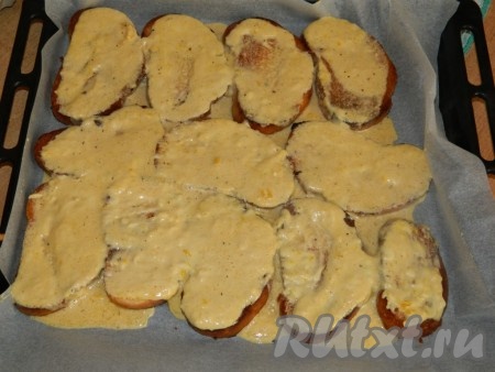 Обжаренные кусочки батона выкладываем на противень, застеленный бумагой для выпечки, заливаем сырно-сливочным соусом и запекаем 5 минут в разогретой духовке при температуре 180 градусов.
