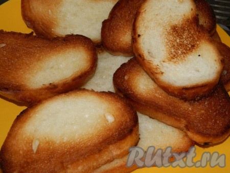 Батон режем на кусочки и обжариваем каждый кусочек на растительном масле с двух сторон.
