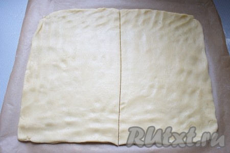 Затем тесто достать. На рабочую поверхность расстелить пергамент, чуть присыпать мукой и раскатать на нем тесто в прямоугольник по размеру стандартного газового противня, толщиной до 3-4 мм. Тесто разрезать на две равные части и вместе с пергаментом перенести на противень. Выпекать 15-18 минут до чуть золотистого цвета.

