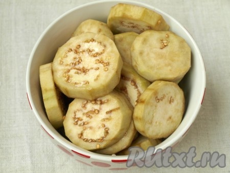 Почистить баклажаны и нарезать их кружочками. Сложить в тарелку и посолить. Оставить на 20-30 минут.