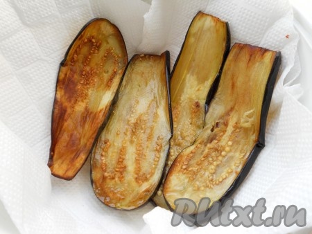 Выложить жареные баклажаны на бумажную салфетку для удаления лишнего жира, а затем переложить на тарелку, дать остыть. Аналогично постепенно пожарить все баклажаны, дать им остыть.