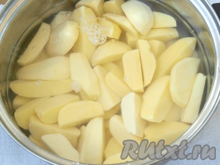 Картофель почистить и разрезать вдоль на 4 части. Залить водой и сварить до полуготовности.