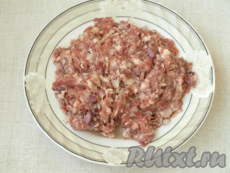Красный лук мелко нарезать и смешать его с мясным фаршем. Добавить молотый красный перец и соль, хорошо вымесить фарш. 
