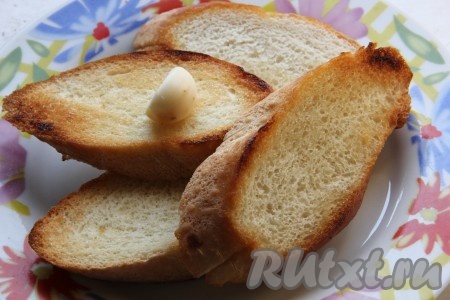 Багет нарезать на средней толщины ломтики. Обжарить ломтики багета с двух сторон на растительном масле до золотистости. Обжаренный хлеб натереть обильно чесноком с одной стороны.
