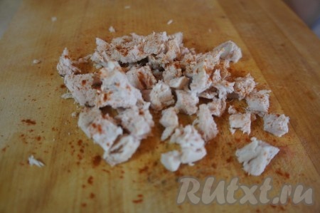 Куриное филе вымыть, переложить в кастрюлю, залить полностью водой и поставить на огонь. После закипания воду подсолить и варить мясо на небольшом огне минут 25-30. Затем мясо достать, остудить, нарезать на средние кубики, по желанию, посыпать специями (у меня - паприка).