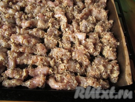 Противень застелите бумагой для выпечки и достаточно обильно смажьте растительным маслом. Выкладывайте куриные кусочки на противень в один слой.