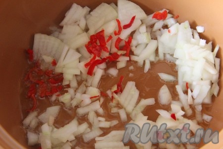 Отдельно в казанке обжарить мелко рубленный лук, острый перец и чеснок. 