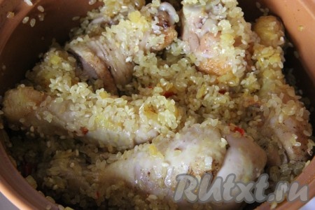 В казанок добавить курицу и рис. Все перемешать и дать рису впитать в себя все масло.