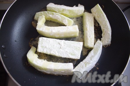 Затем кусочки кабачка обвалять в муке и обжарить на сковороде с растительным маслом до румяного цвета со всех сторон.