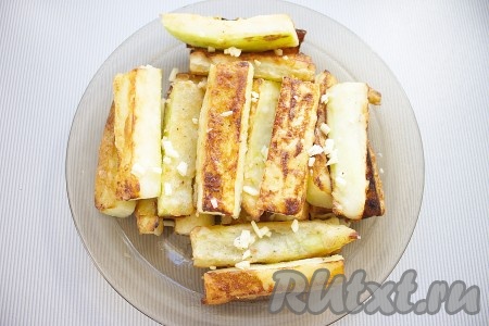 Обжаренные брусочки кабачка выкладывать на блюдо и пересыпать измельченным чесноком.