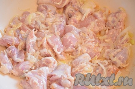 К обжаренному луку добавить кусочки куриного мяса, перемешать, жарить 10 минут, иногда перемешивая.