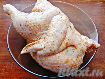 Половинку тушки курицу вымыть, натереть солью и специями со всех сторон, оставить на 1 час (можно поставить в холодильник и на более длительное время), чтобы мясо хорошо просолилось и пропиталось специями.