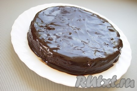 Тёплую заливку вылить сверху на корж и равномерно распределить по поверхности и боковинам коржа (удобно делать силиконовой лопаточкой или широким ножом). Дать торту полностью остыть, а заливке застыть (в холодильник ставить не надо!).