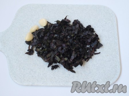 Мелко нарезанный базилик растираем в ступке с порубленным чесноком и мелко порезанными грецкими орехами и солью (при желании можно не растирать в ступке, а перемолоть в блендере).
