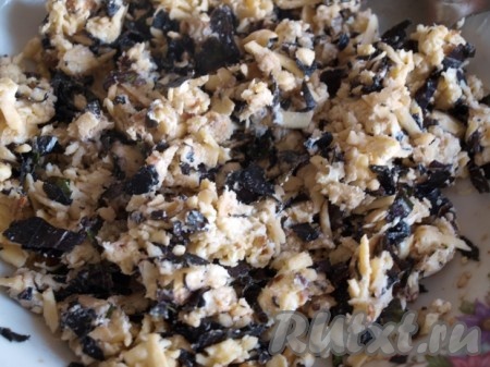 Сыр натираем на тёрке и тщательно перемешиваем со сливочным маслом до однородной массы, затем добавляем смесь из орехов, базилика и чеснока. Ещё раз перемешиваем.
