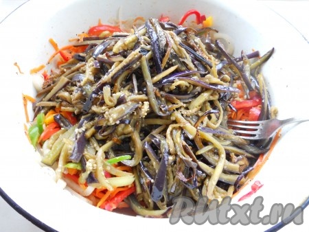 Баклажаны отжать, жидкость удалить и обжарить на растительном масле до готовности (минут 10-15). Горячими добавить баклажаны к остальным ингредиентам. Также добавить порезанный мелко горький перец.
