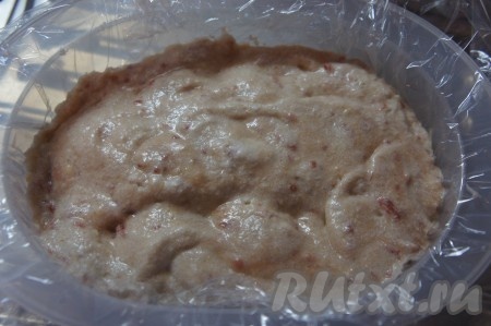 Чашу для риса (обычно идёт в комплекте с пароваркой) застелить пищевой плёнкой так, чтобы достаточно длинные края плёнки свисали с краёв формы, выложить получившееся тесто.