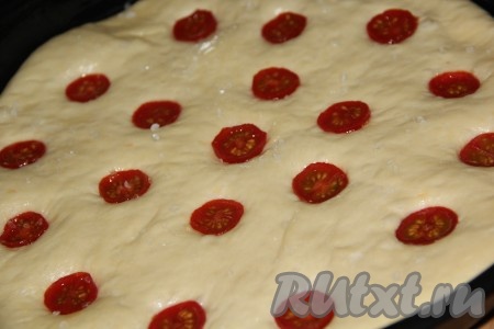 Помидоры вымыть, обсушить. Выложить половинки помидоров черри срезом вверх в лунки. Прикрыть форму полотенцем и оставить ещё на 20 минут.&nbsp;Затем сбрызнуть фокаччу с помидорами оставшимся маслом, присыпать крупной солью и поставить в заранее разогретую духовку.