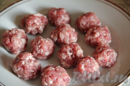 Для получения фарша нужно пропустить кусочки мяса через мясорубку, при желании можно взять и покупной фарш. Фарш перекладываем в миску, солим, перчим и формируем из него небольшие шарики - фрикадельки, как на фото.