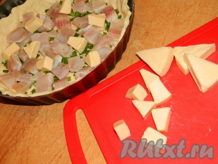 На рыбу разложить сыр. Я готовила с плавленным сыром, поэтому нарезала его на кусочки. Сыр твёрдых сортов можно натереть на крупной тёрке.