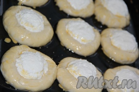 Разогреваем духовку до 200 градусов. Смазываем поверхность ватрушек взбитым яйцом и ставим в духовку.