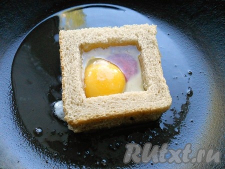 И сразу же вбить яйцо. Посолить и накрыть сковороду крышкой. Жарить также на минимальном огне минуты 3, после чего крышку снять.