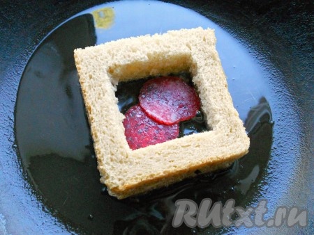 Сверху накрыть вторым ломтем хлеба, чуть придавить. В серединку поместить пару кусочков колбаски.