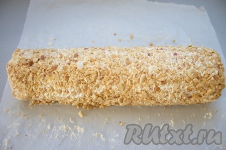 Насыпать орешки на пергамент, взять пергамент за края и покатать рулет, чтобы орешки хорошенько прилипли к поверхности. 